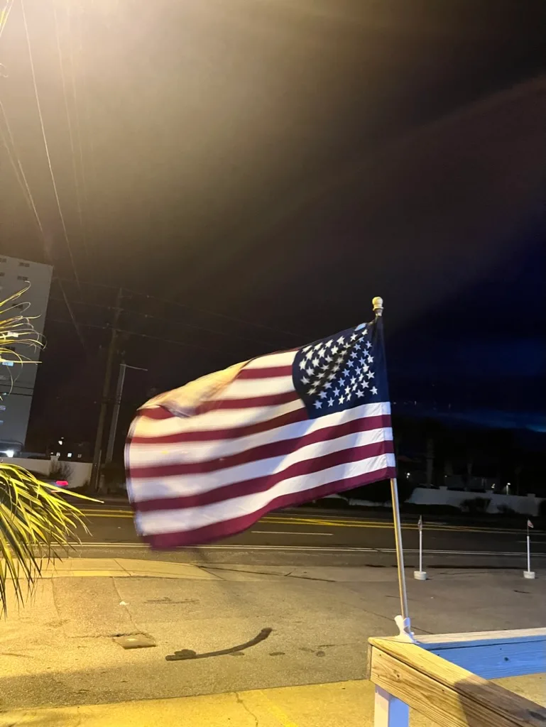 American flag flying at night outside Buster's Beer and Bait, Panama City Beach